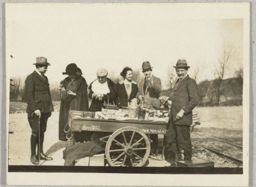 Travelling merchant with a handcart and a few customers