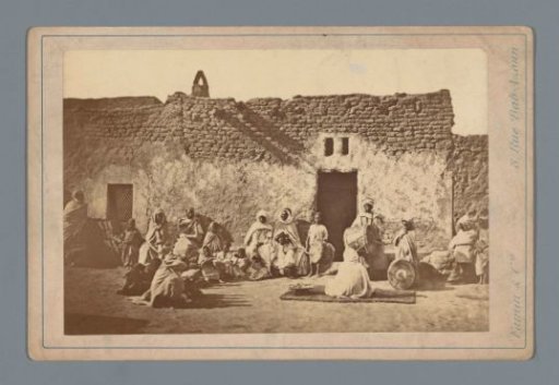 Facade of a café in Algiers with people in traditional dress
