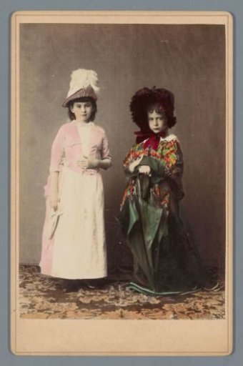 Portrait of two unknown girls wearing hats and an umbrella