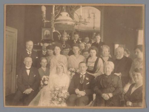 Group portrait with an unknown bride and groom in the foreground