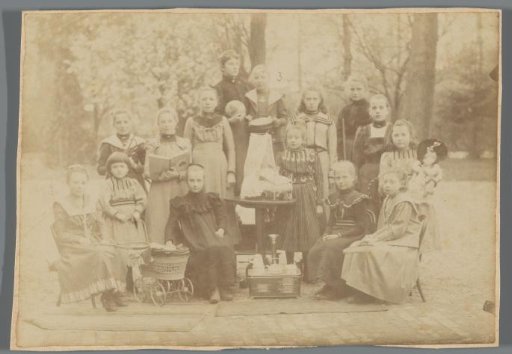 Group portrait of unknown girls with toys in a garden