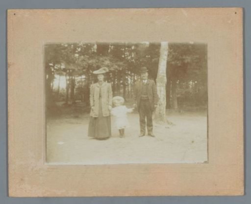 Group portrait of a family with a child in (presumably) a park