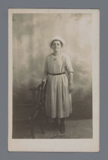 Studio portrait of an unknown woman next to a chair