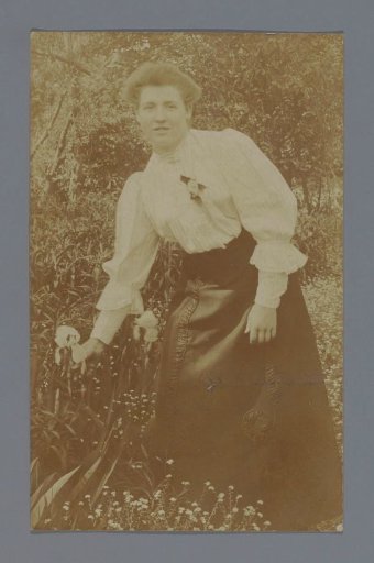 Portrait of an unknown woman picking a flower