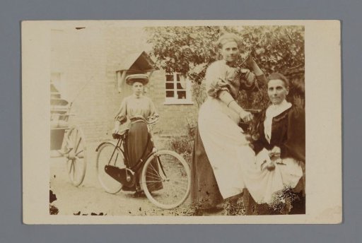 Portrait of two unknown women and a woman with a bicycle