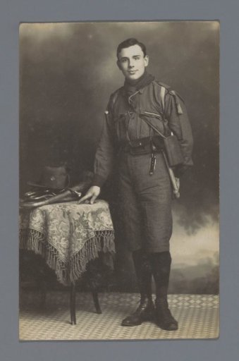 Portrait of an unknown man in uniform next to a table with a trumpet