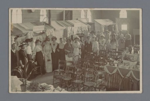 Group portrait of unknown women in an event hall, possibly members of a charity during a charity event
