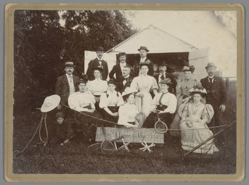 Group portrait of an unknown company with tennis rackets and a board with the text "Hurry-Up"