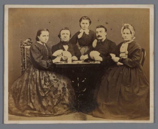 Group portrait of a card-playing company around a table