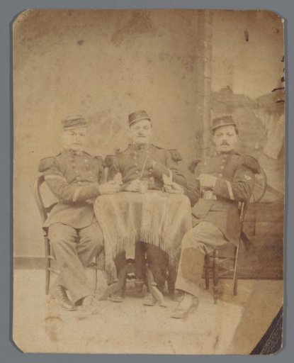 Portrait of three soldiers around a table