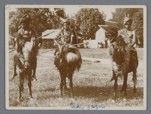Three warriors with spears on horses (presumably) in New Guinea
