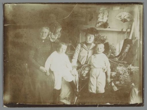 Group portrait of an unknown family with children in a greenhouse