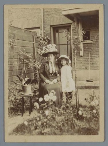 Portrait of an unknown woman with a child in a backyard in The Hague