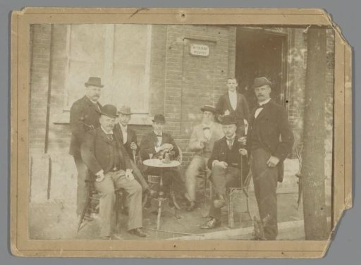 Group portrait of eight unknown men on the terrace in front of an officers' club