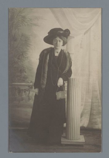 Studio portrait of an unknown woman beside a column