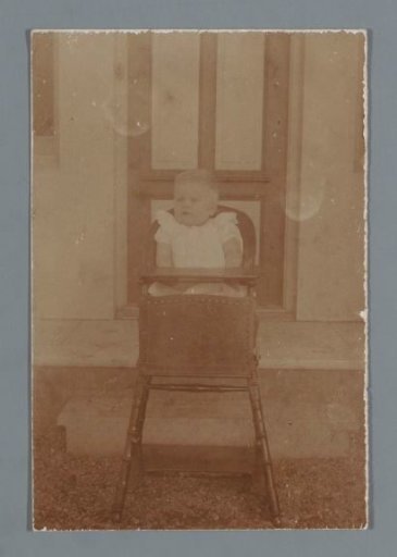 Portrait of an unknown child in a high chair