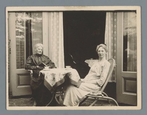 Portrait of two unknown women on a terrace behind a house