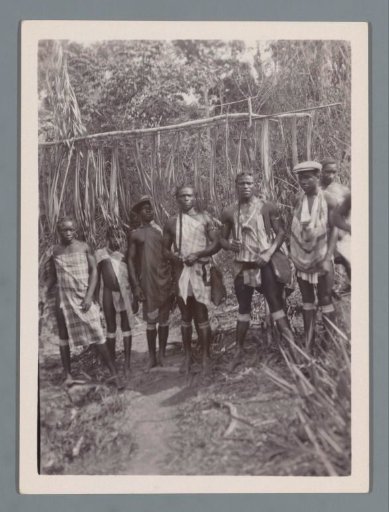 Seven Marron men in front of the entrance to a Marron village (probably) in Suriname