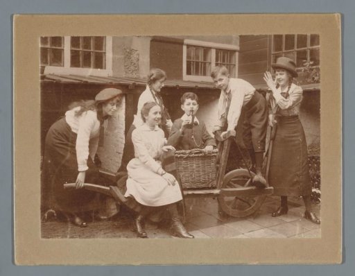 Group portrait of Ad, Han and Johanna van der Kop and three unknown family members around a cart in a garden