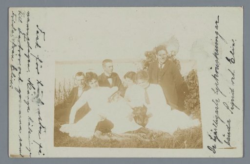 Group portrait of an unknown group before a lake
