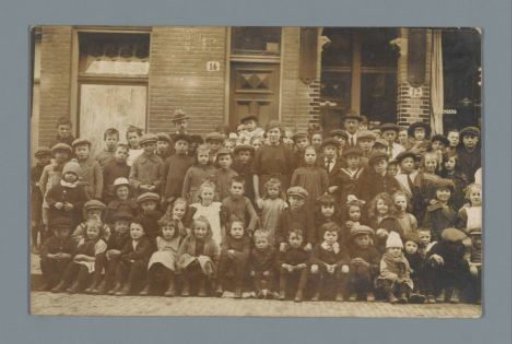 Group portrait of children and (presumably) teachers in a street