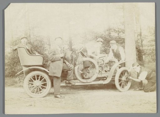 Group of young men working on a car