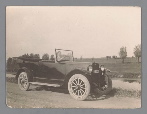 Unknown man in a car next to a meadow