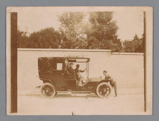 Three unknown men around a car