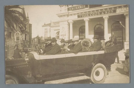 Unknown company in an open bus in front of a Thomas Cook & Son office