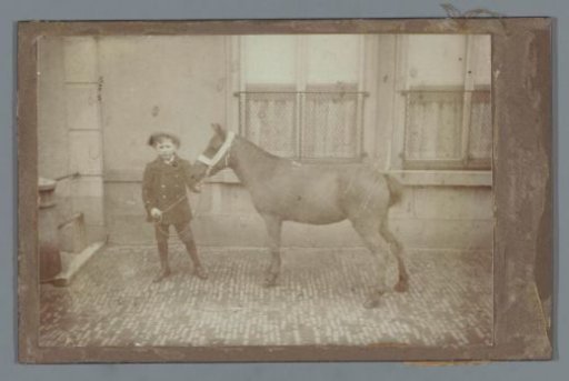 Boy with a horse in front of a house (presumably) in The Hague