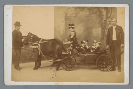 Six children in a horse-drawn carriage with two unknown men on either side