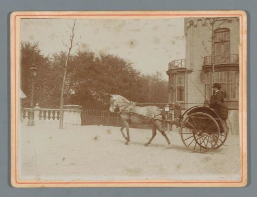 Unknown man in a carriage with a horse in front of a country house