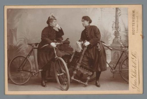 Studio portrait of two unknown women with bicycles