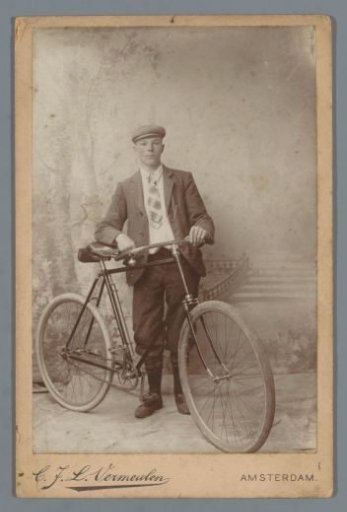 Studio portrait of an unknown man with a bicycle