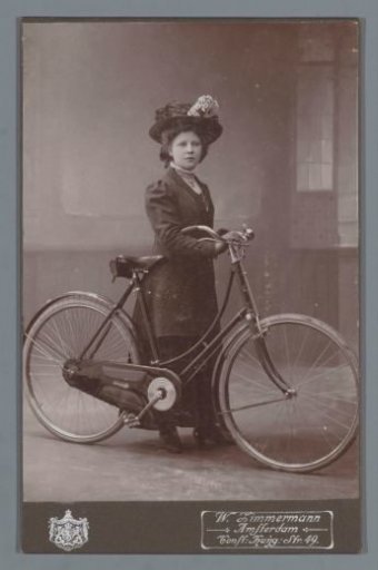 Studio portrait of an unknown woman with a bicycle