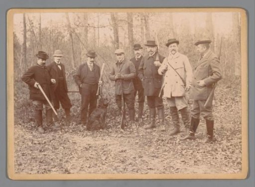 Group portrait of hunters with a dog in a forest