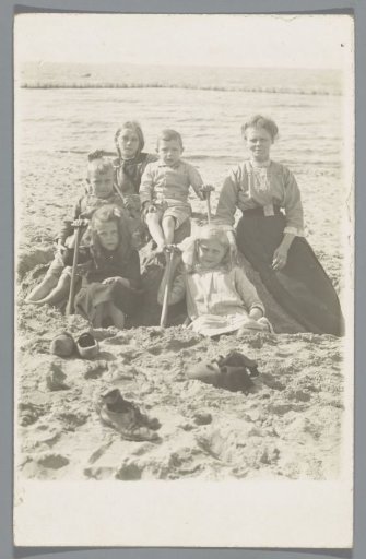 Group portrait of an unknown woman with five children on the beach