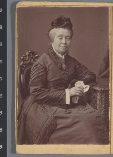 Portrait of an unknown woman, seated at a table