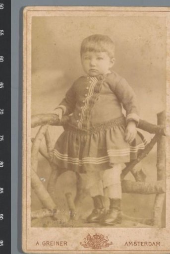 Portrait of an unknown child, standing next to a fence