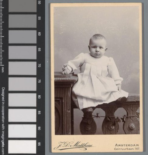 Portrait of an unknown baby, seated on a fence