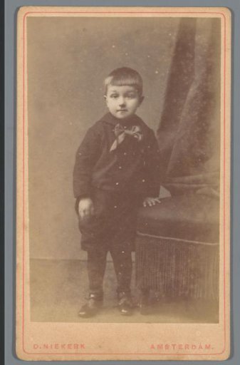 Portrait of an unknown boy, standing next to a chair
