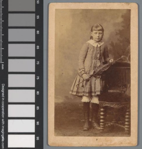 Portrait of an unknown girl, leaning against a chair with an umbrella in her hand