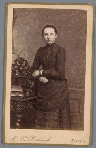 Portrait of an unknown woman, standing next to a desk