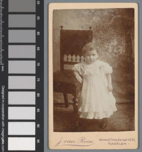 Portrait of an unknown girl, standing beside a chair