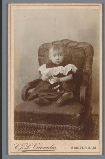 Portrait of an unknown child, sitting in an armchair
