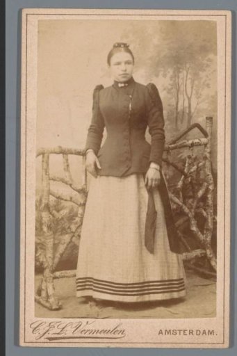 Portrait of an unknown woman, standing before a fence