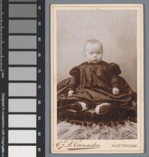 Portrait of an unknown baby, seated on a cushion