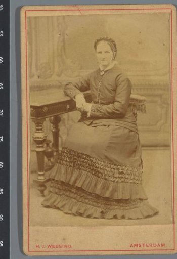 Portrait of an unknown woman, seated at a table