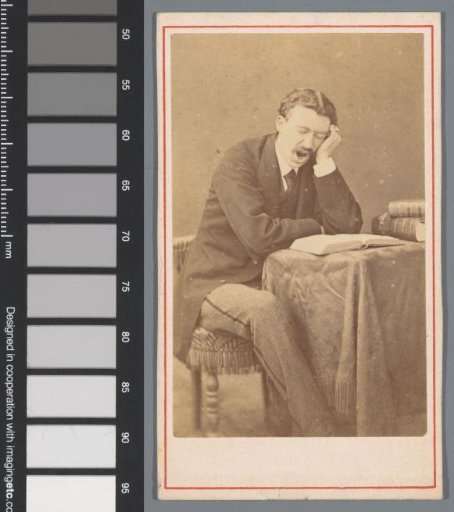 Portrait of an unknown yawning man, seated at a table with an open book