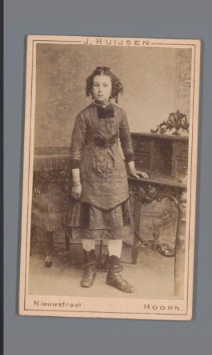Portrait of an unknown girl, standing beside a desk